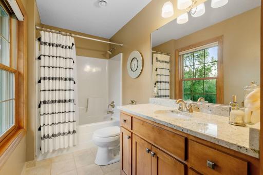Full bathroom w/ large vanity cabinet granite top & linen closet, ceramic tile flooring and natural light!