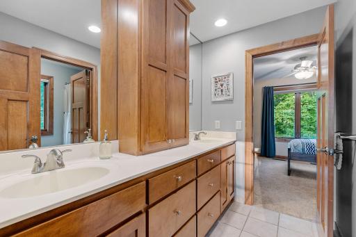 Large vanity cabinet w/ dual sinks and additional medicine cabinet w/ ceramic tile flooring in the Jack & Jill bathroom