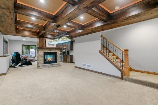 See-through gas fireplace w/ cultured stone surround & rustic alder mantel in the Family Room