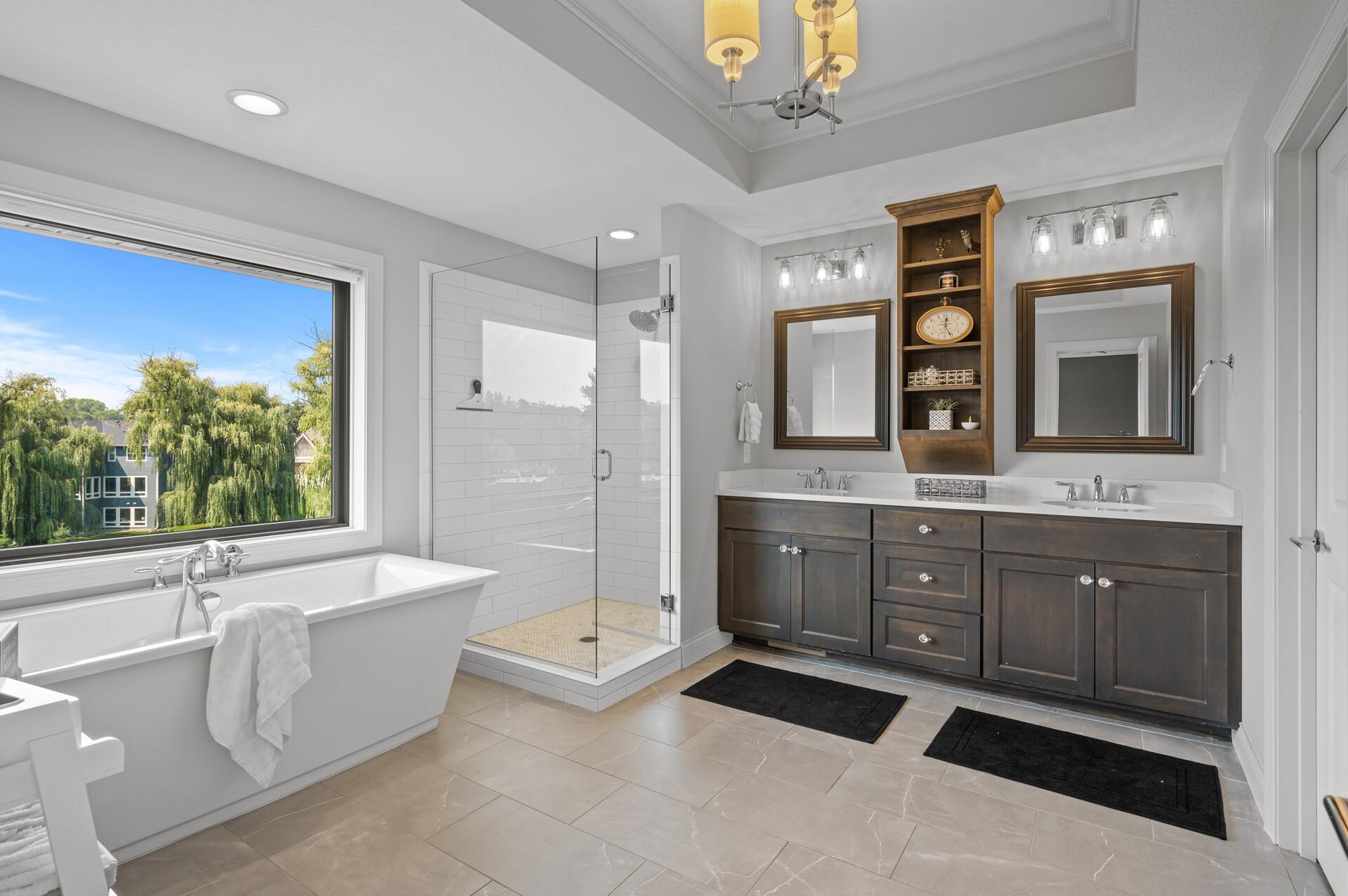The primary bathroom boasts a large free-standing soaking tub, a separate shower, dual sinks, and high-end finishes for a spa-like experience.