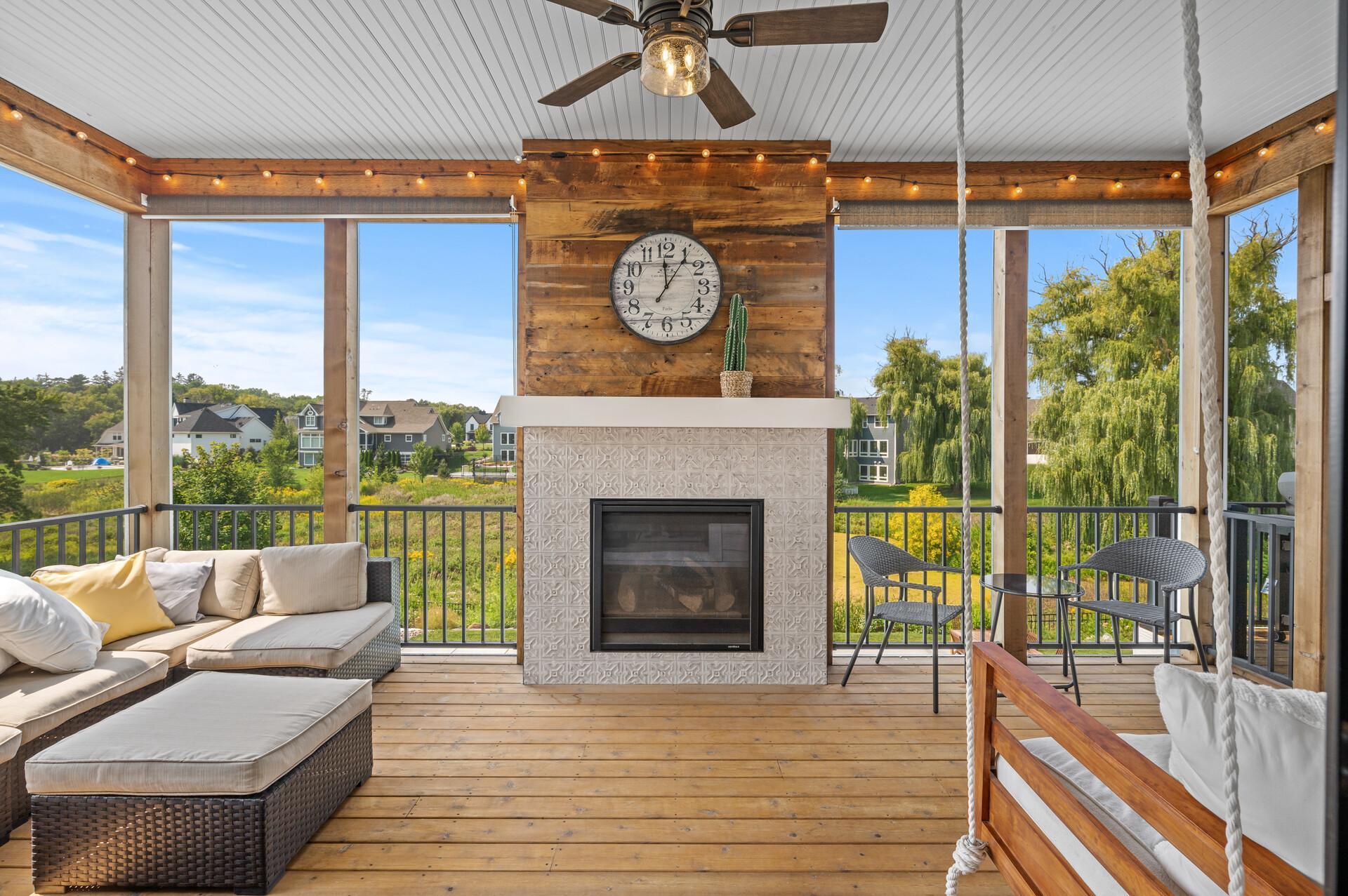Unforgettable screen porch complete with a cozy bench swing and a gas fireplace, offering a unique and comfortable space to unwind while enjoying the outdoor ambiance.
