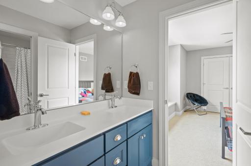 Jack & Jill bathroom with dual sinks, private water closet with tub/shower combo offering classy subway tile surround.