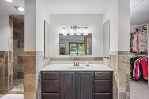 Private primary bathroom includes classy stone finishes and a tiled walk-in shower.