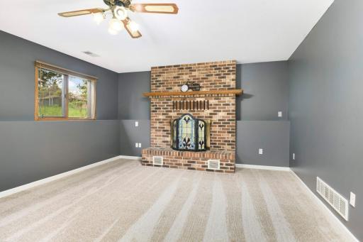 Retreat to the lower level family room! Warm up to the brick fireplace in the colder months.