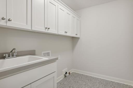 Laundry room offers sink & upper cabinetry