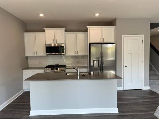 This spacious kitchen features a sizeable pantry, quartz countertops, LVP wood floors, stainless steel appliances and more!