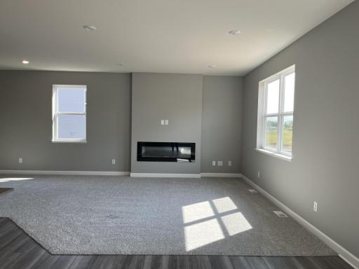 Cozy and contemporary, the main level family room comes furnished with a stunning electric fireplace.