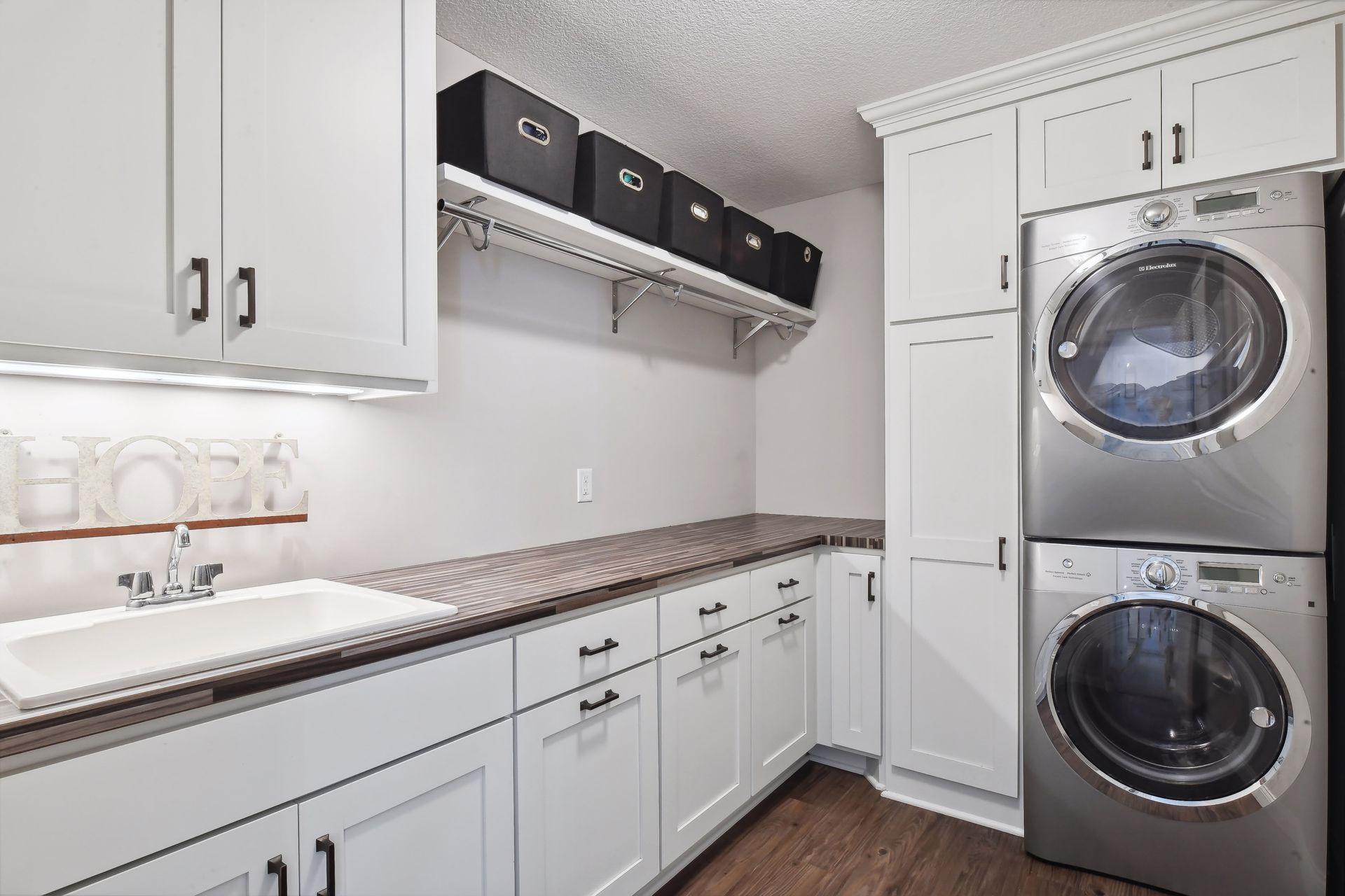 Conveniently located on the upper level is the Laundry Room where you will find extensive built-in cabinetry, a stacking Electrolux washer and steam dryer and a built-in ironing board.