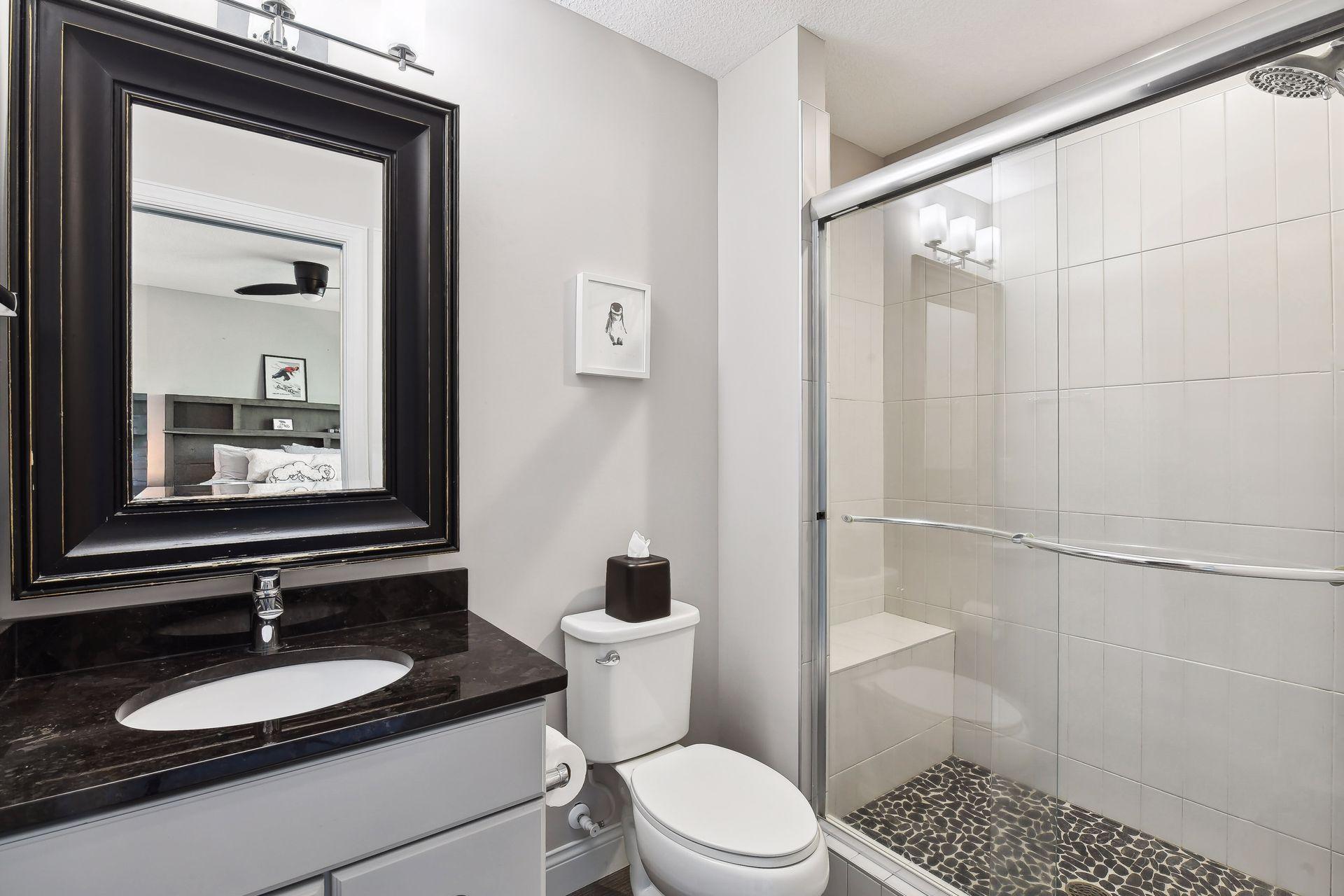The private 3/4 en suite bathroom offers a tiled shower and vanity with granite countertop.