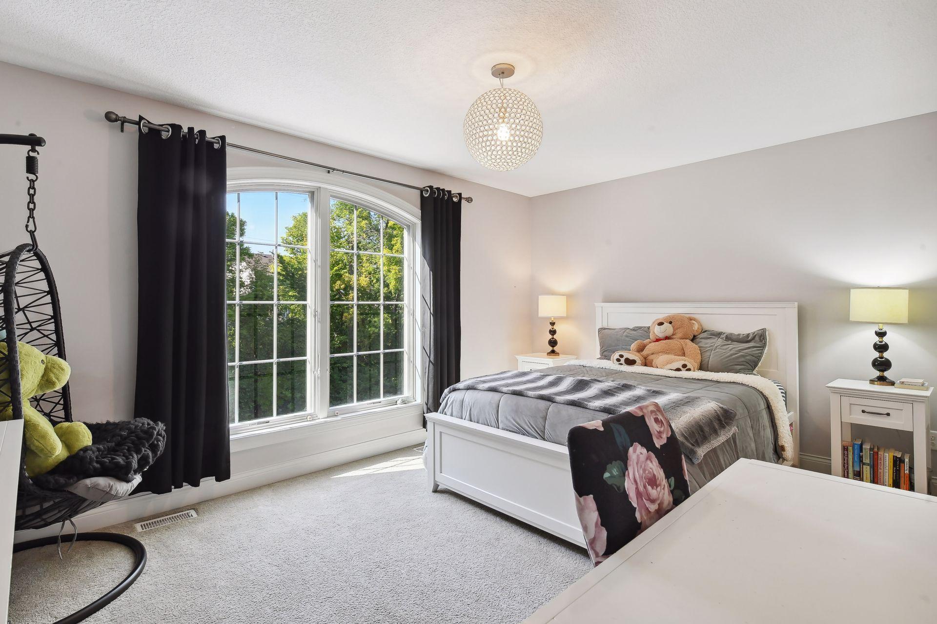 Illuminated by a designers light fixture, the second Junior Suite features a beautiful arched window and walk-in closet with a California Closet system.