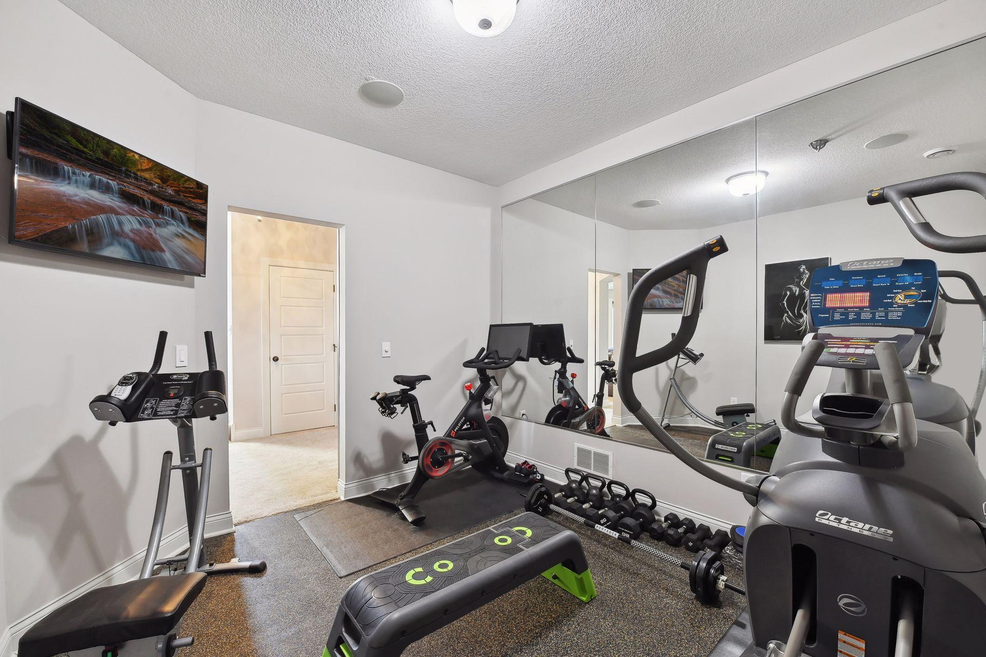 The Exercise Room is tucked away behind a custom barn door and features a rubber mat flooring, wall of mirrors and built-in ceiling speaker so you can workout to your favorite tunes.