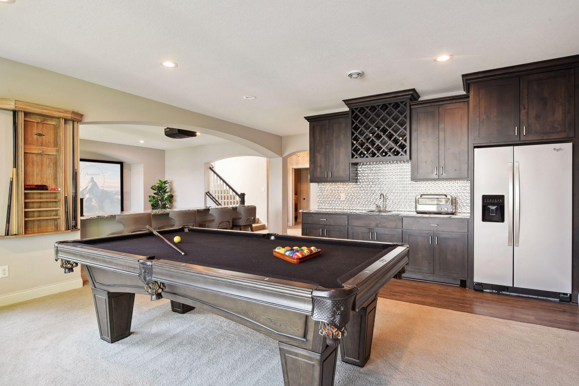 Designed for fun and entertainment, the lower level features a walk-up wet bar with storage for your wine collection, a full-sized stainless steel refrigerator and designer tile backsplash.