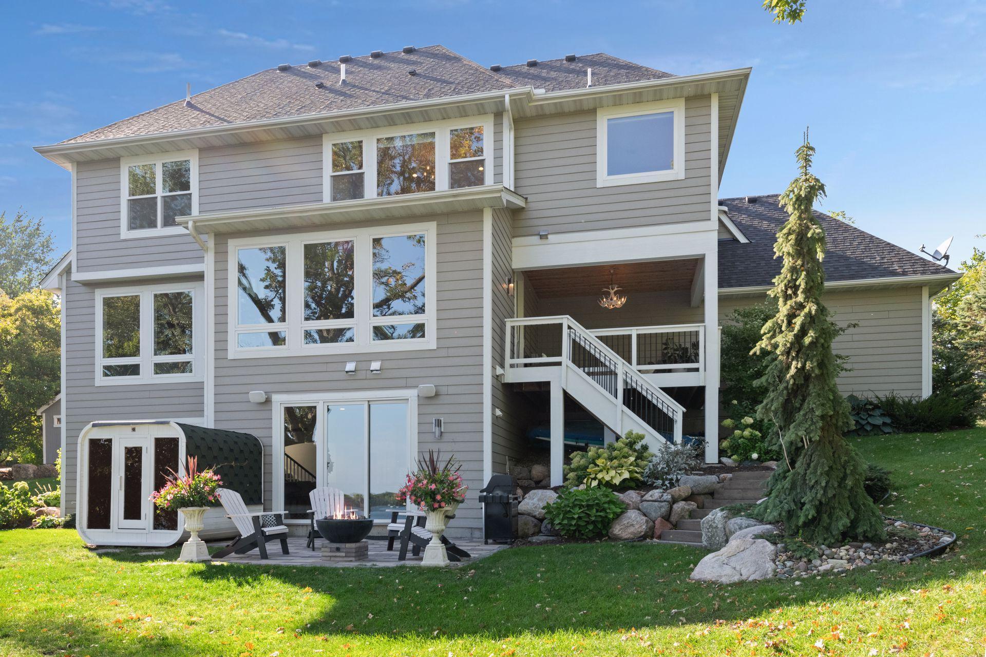 The home is surrounded with professional landscaping that features flowering shrubs, lush hostas and evergreen trees.