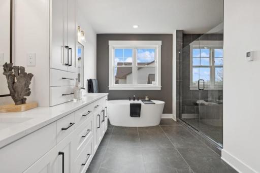 Luxurious owner's bath with heated floors, a large shower with 2 shower heads and bench, ample cabinetry space and a soaking tub to top it off!
