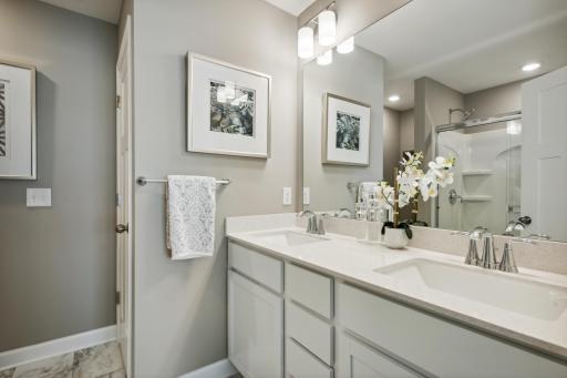 The 3/4 owner's bathroom offers a double vanity with quartz countertops, a linen closet, and shower. *Photos are of a model home; actual features and colors will vary.