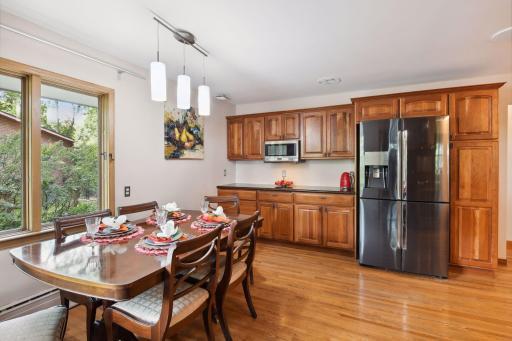 Charming dining area, bathed in natural light from the large windows.. Adjacent to it, the kitchen boasts an abundance of additional cabinets and wide counter space, providing ample storage and a chef's dream workspace.