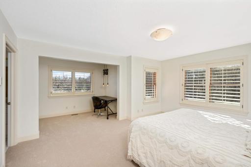 This upper level bedroom features an alcove perfect for a study or lounging area.