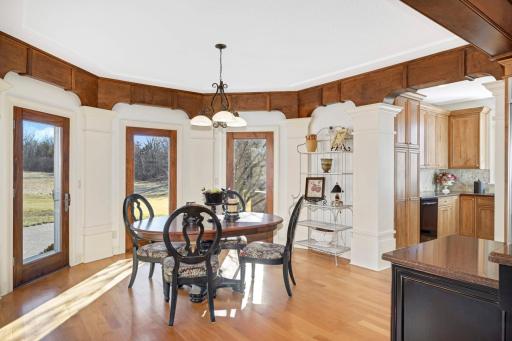 The informal dining area opens up to the outdoor patio and acres of possibilities. The convenient butler's pantry can be seen to the right.