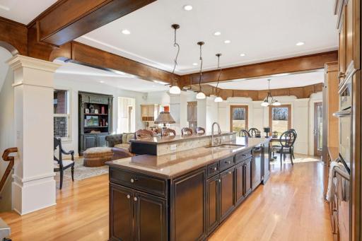 The open kitchen features a large center island with a breakfast bar, a family room area, and an informal dining area that opens up to a large outdoor patio.