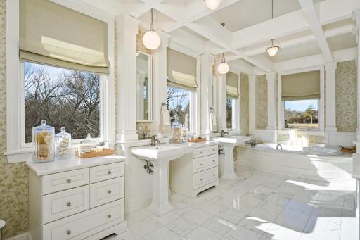Indulge in luxury and relaxation in this spa-inspired primary bathroom with a vaulted ceiling, double sinks, and a spacious spa tub.