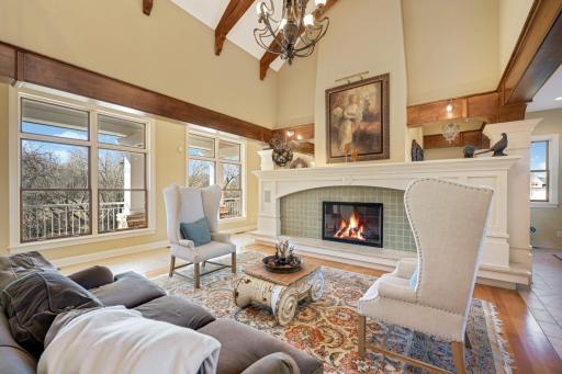 The living room features a gas fireplace, a vaulted ceiling, and an abundance of windows offering natural light and views of the grounds.