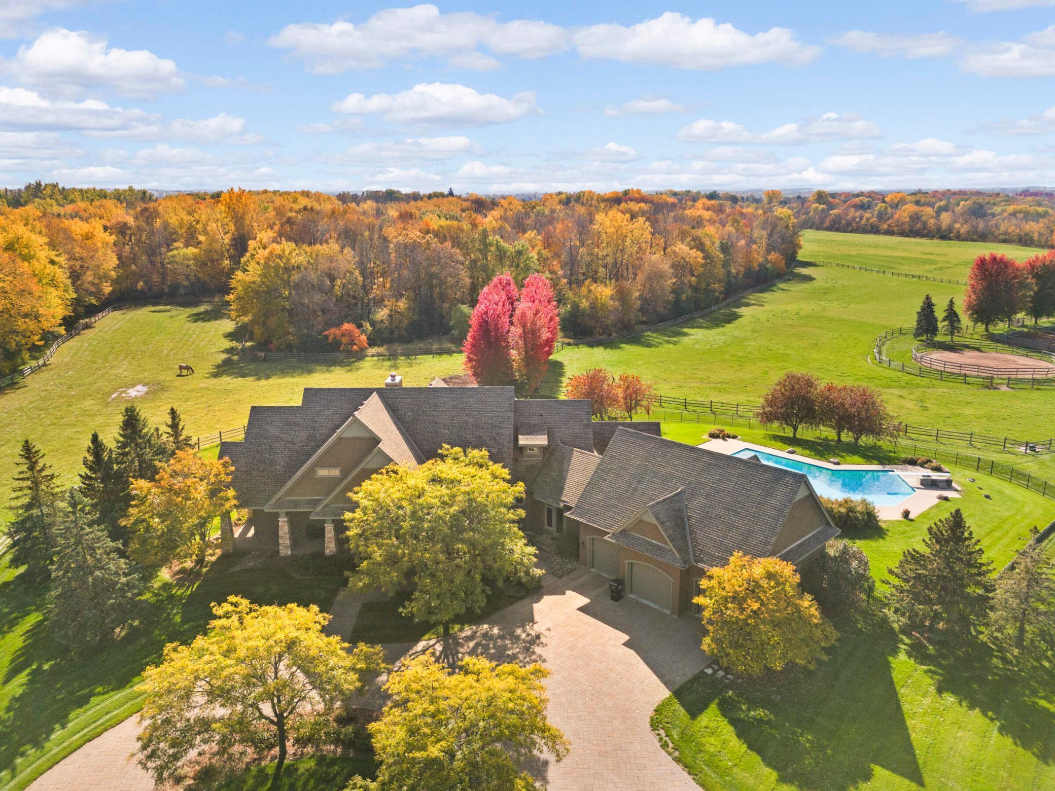 Aerial view of house, pool, pastures and woods
