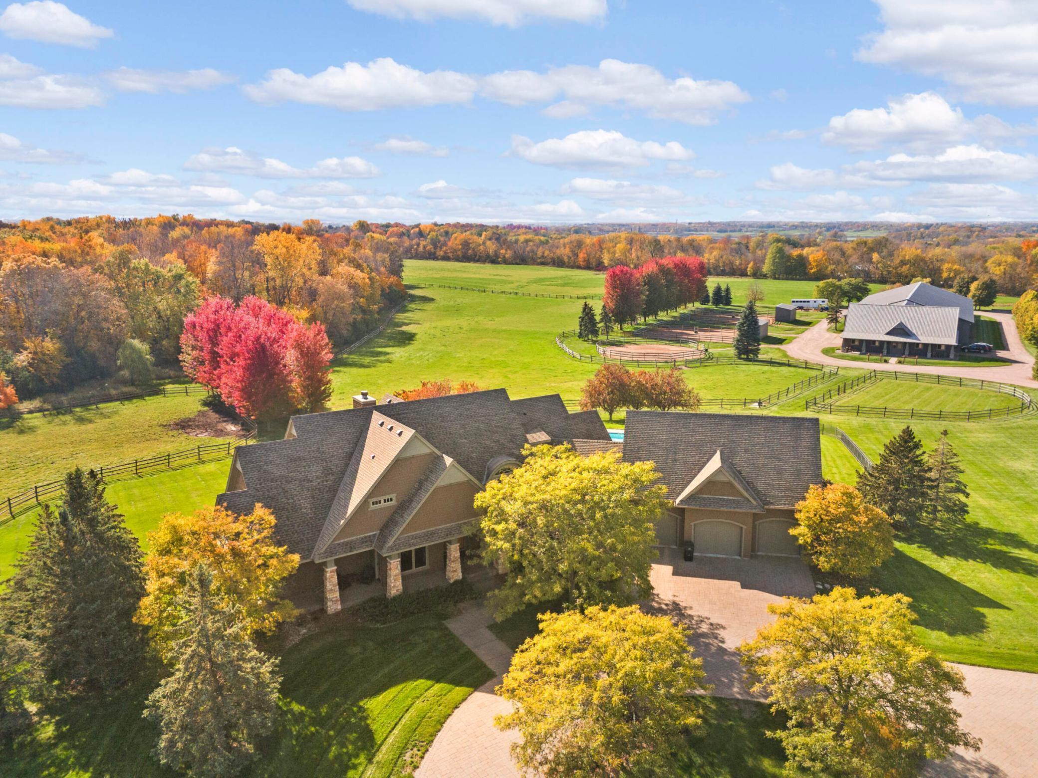 Aerial view of the house, equestrian facilities, pastures, and woods