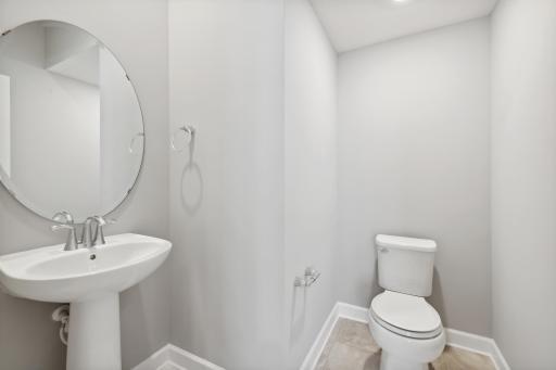 Conveniently located powder room on the main level. (Photo of a completed home, actual home's finishes may vary slightly)