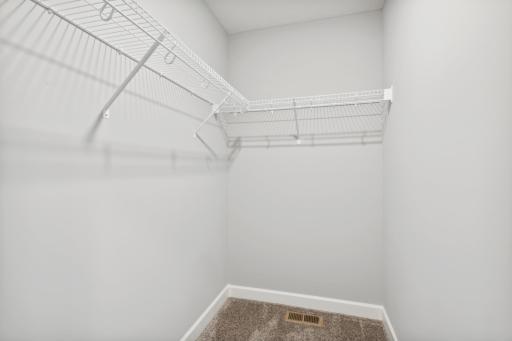 One of the spacious owner's suite walk-in closets. (Photo of a completed home, actual home's finishes may vary slightly)