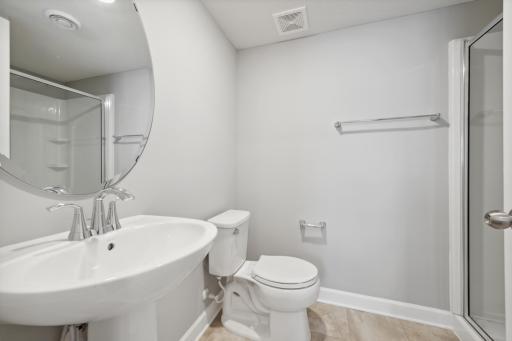 Potential for a full finished bath in the lower level for a guest suite. Plumbing rough-ins are included. (Photo of a completed home, actual home's finishes may vary slightly)
