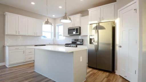 Thoughtfully-designed with a combination of functionality and modern design, this kitchen space is sure to impress. (Photo of completed home, actual home finishes may vary slightly)