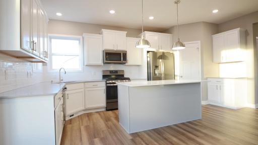The open layout provides an optimal area to cook and entertain. Envision gathering together with friends and family in the heart of this home over the holidays! (Photo of completed home, actual home finishes may vary slightly)