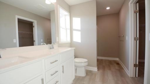 An extension of the owner's suite, this private and spacious bath contains a double-vanity and access to the walk-in closet. (Photo of completed home, actual home finishes may vary slightly)