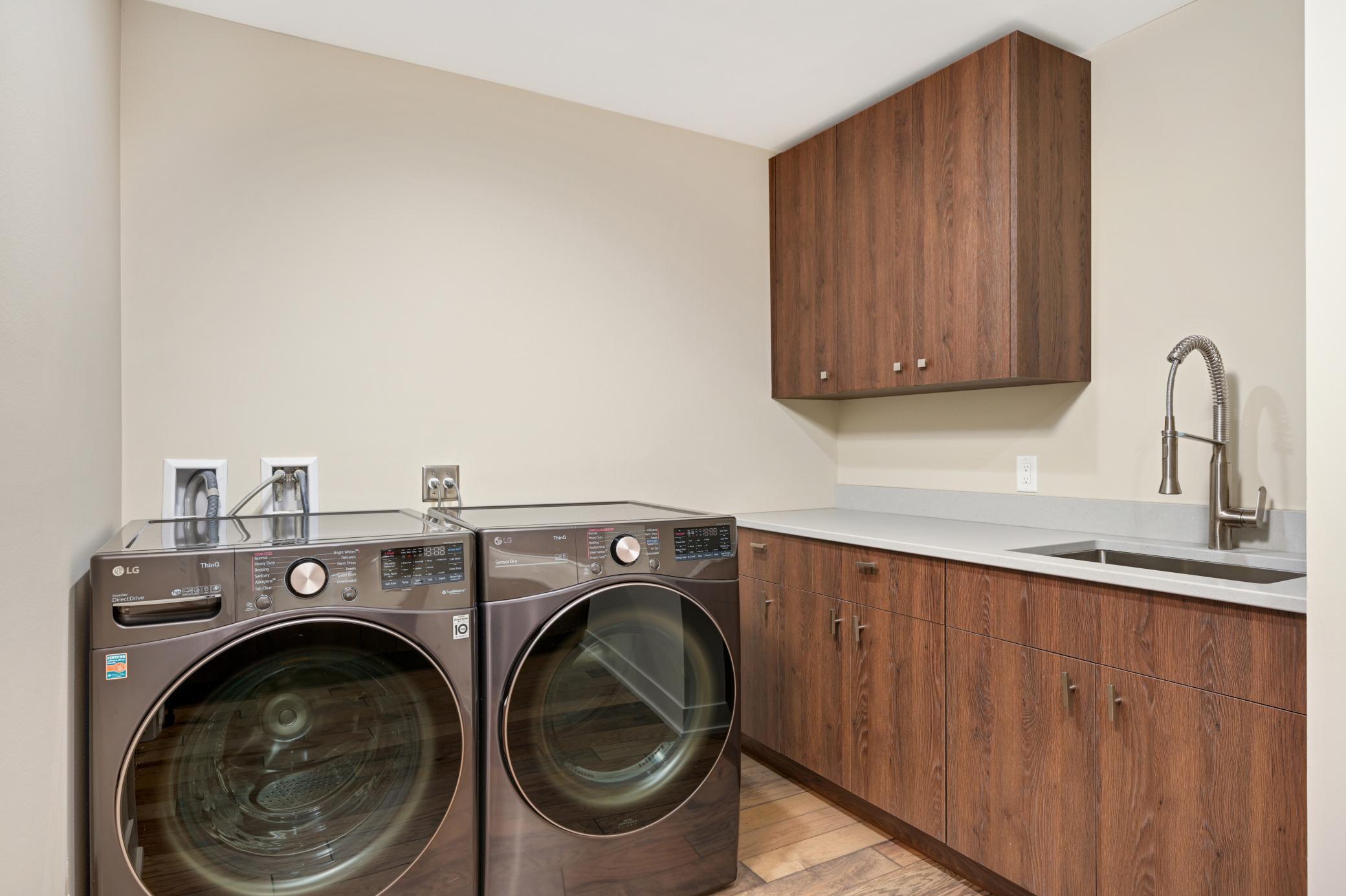 Main laundry room with built-ins, counter space and sink