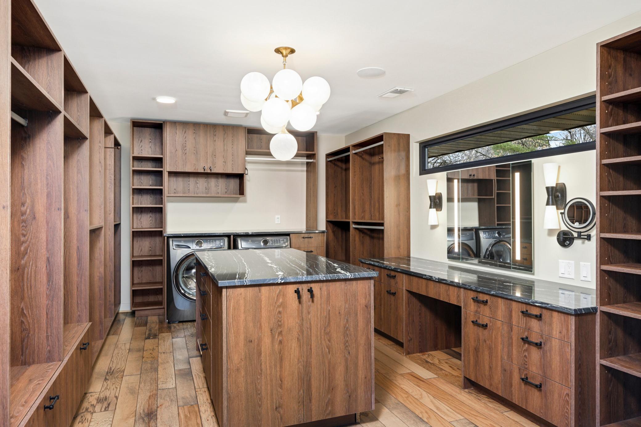 Now... That's a walk-in closet!!! With additional power room vanity counter, loads of built-ins, center island, primary laundry and built-in safe