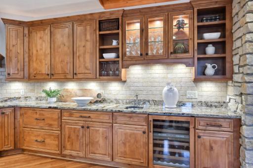 Beverage fridge and beautifully lit cabinetry.