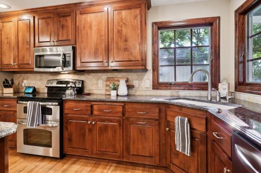 Highlights of the kitchen include SS appliances, granite tops, walk-in pantry, wonderful cabinet space for storage, and south-facing windows