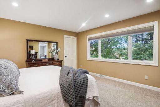 Spacious primary suite offering a private view of the natural surrounding out back