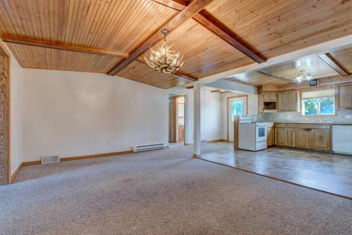 A view of the dining and kitchen space also shows the hallway to the bedrooms, bathroom, and bonus room