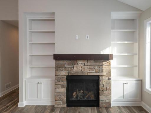 A gas fireplace flanked with display cabinets and media component storage within the cabinets.
