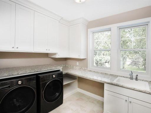 This home has a huge laundry room, with custom cabinets, crown moldings and tiled floors.