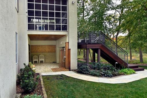open-air shower flanks a pool storage garage with overhead door opener