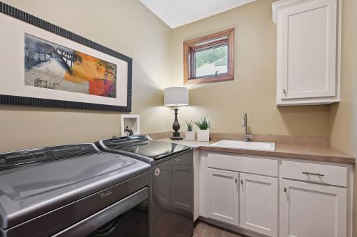 The Laundry Room is equipped with Whirlpool appliances, a laundry sink and storage cabinetry.