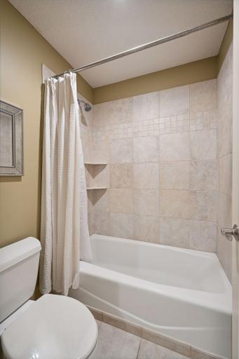 The Jack-and-Jill bathroom includes a private water closet with a tiled bathtub and shower surround.