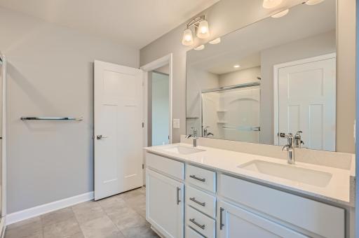 The owners bath is spacious and sparkles too. Double quartz top vanities, shower, private water closet area and a window. Finishes will vary.