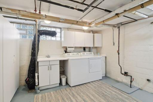 The laundry room has many cabinets and storage areas