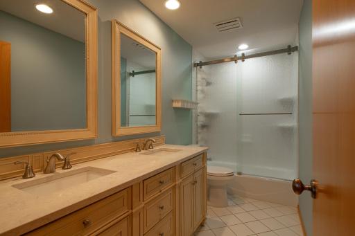 Upper level full bath recently updated with double sinks and rain glass doors
