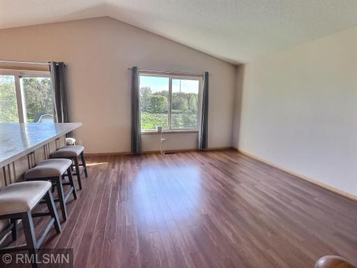 The spacious vaulted living room has recently added new flooring. Great view of the backyard and pond.