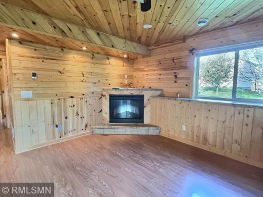 The corner fireplace blends nicely with knotty pine. Great spot to get cozy on those chilly nights.