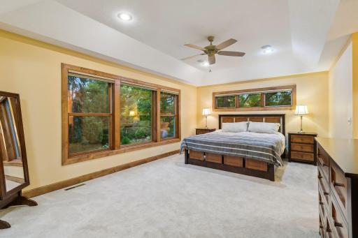Oversize Primary bedroom features tray ceiling, ceiling fan, security panel